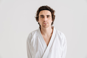 Obraz premium Young caucasian sportsman dressed in kimono posing at camera