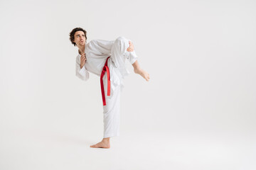 Fototapeta na wymiar Young caucasian sportsman dressed in kimono practice in karate