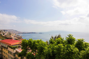 Top view on the embankment of Naples. Panoramic seascape of Napoli city with view of the port in the Gulf of Naples. Mount Vesuvius covered by fog. The province of Campania, Italy.