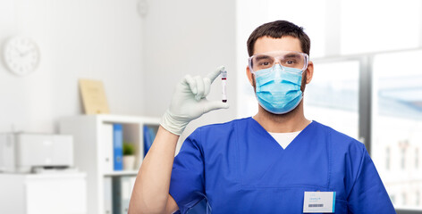 Fototapeta na wymiar healthcare, profession and medicine concept - doctor or male nurse in blue uniform, face mask, goggles and gloves with blood in test tube over medical office at hospital on background