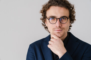 Focused handsome man in eyeglasses posing and looking at camera