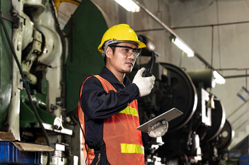 Engineer talking radio communication call machine Engineer and hold on tablets for solution process of product in factory with confident