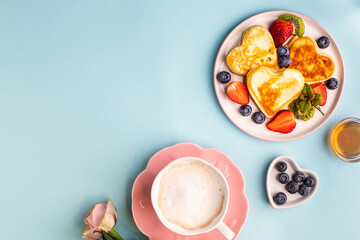 Valentine's day flat lay with heart shaped pancakes on a blue background. Valentine's Day concept. View from above. Copy space