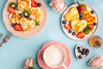 Valentine's day flat lay with heart shaped pancakes on a blue background. Valentine's Day concept. View from above.