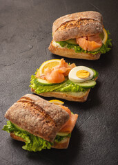Sandwiches with smoked salmon, salad, cucumbers and eggs.