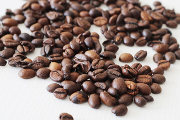 roasted coffee beans on white wooden background