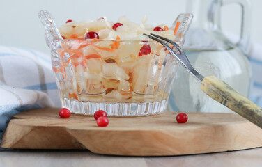 Homemade sauerkraut with lingonberries in glass jar on a white background. Fermented product.