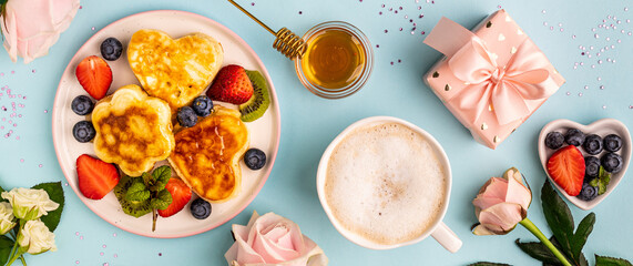 Valentine's day flat lay with heart shaped pancakes on a blue background. Valentine's Day concept. View from above. Banner