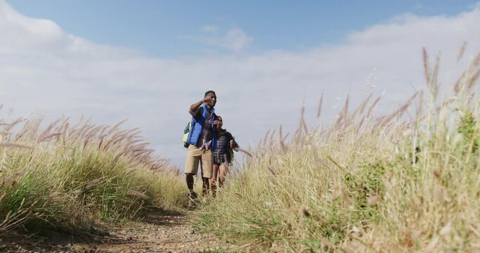 African american couple walking while trekking in the mountains