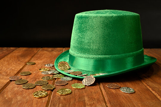 St. Patrick's concept. Green hat and lucky coins on black background.