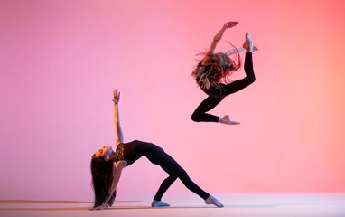 Foto op Canvas two ballet girls with long loose hair in black tight-fitting suits dancing © Maria Moroz