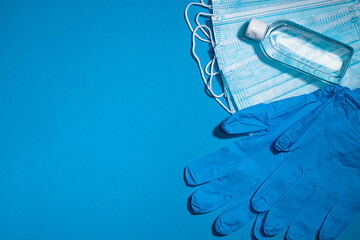 Medical gloves mask and alcohal gel for protecting infection during Coronavirus pandemic top view on light blue banner background with copy space