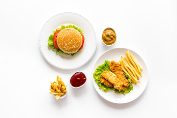 Fast food flat lay set. Burger with fried potatoes and chicken, top view
