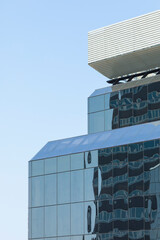 Fototapeta premium Close-up of an anonymous office building in Madrid, Spain, under the scorching summer sun. A closed work space, sterile for life and built with concrete, steel and glass.