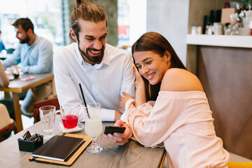 Young happy couple at a date in a coffee shop
