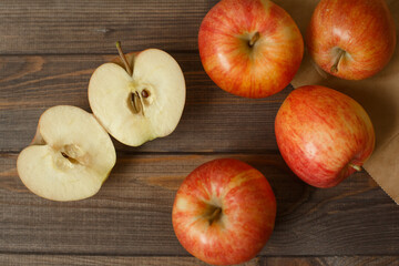 Red apples in a paper bag wooden background