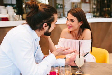 Young happy couple at date in a cafe