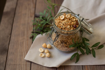 Breakfast muesli and nuts muesli in a jar on a wooden background. Spilled muesli.
