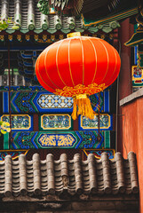 Dekorativer roter chinesischer Ballon - mit historischen Architekturdetails im Hintergrund
