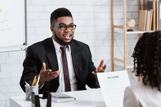 Human resources manager communicating with positive vacancy applicant on employment interview at office