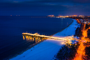 Illuminated pier in Brzezno on the winter beach at dusk, Gdansk.  Poland. © Patryk Kosmider