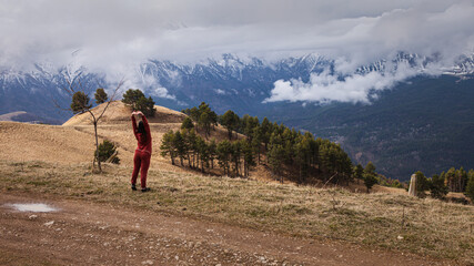 girl tourist exercises in the mountains
