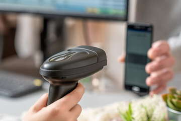 Woman cashier scanning qr code from buyer phone using barcode scanner. Man buying a gift in a female clothing store using promo code.