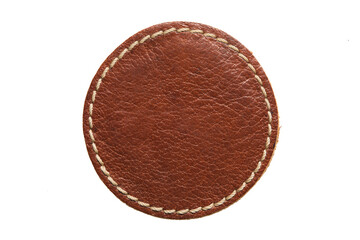 Blank brown round leather label on white background, macro close up. Empty leatherette circular tag