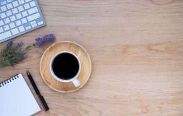 Workplace in office with wooden desk. Top view above of keyboard computer with notebook and pen. Space for modern creative work of designer. Flat lay with copy space. Business-finance concept.
