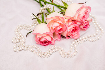 The branch of pink rose on white fabric background

