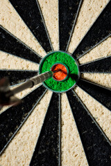 One single dart in bullseye of a professional dartboard, closeup