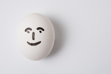 Egg with a happy and joyful person on a white background copy space.