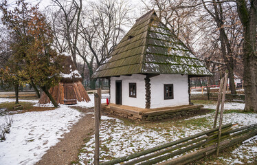 Bucharest Romania - January 2021: Traditional Romanian houses at the Village Museum from Bucharest during a cloudy day after a winter snowfall