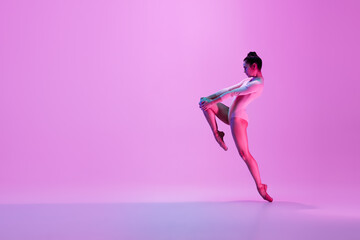 Urban style. Young and graceful ballet dancer on pink studio background in neon light. Art, motion, action, flexibility, inspiration concept. Flexible caucasian ballet dancer, moves in glow. - obrazy, fototapety, plakaty