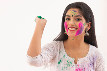 A YOUNG WOMAN READY TO THROW GULAL DURING HOLI	