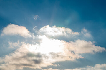 Sunset blue sky, bright sun shines through clouds.