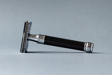 Vintage safety metal and plastic razor on a gray background. Selective focus