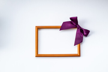 blank photo frame with bow and space for text on a white background. Top view