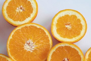 The orange halves are on the table. On a gray and white background.