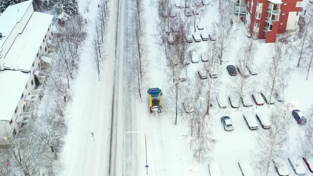 Snowplow is clearing the street after a winter storm.