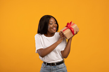 Happy african american woman holding gift box