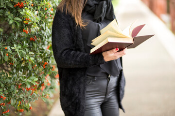 dettaglio di un libro che viene letto da una ragazza in contesto esterno vicino a un assieme con i...
