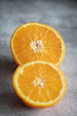 The orange halves are on the table. On a gray and white background.