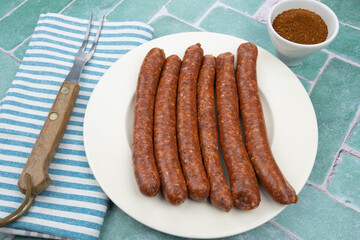 assiette de merguez crues sur une table