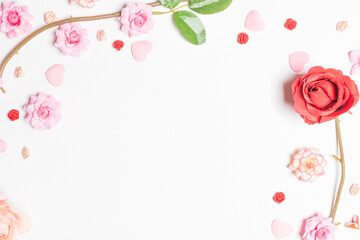 Frame made of rose flowers on white background. Top view with copy space.