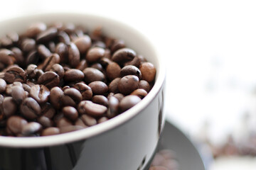 Fototapeta premium roasted coffee beans in black cup