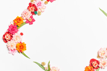 Frame made of rose flowers on white background. Top view with copy space.