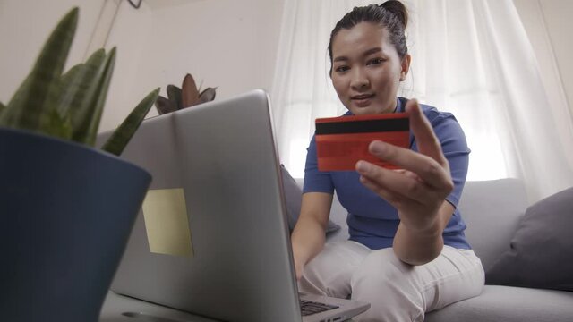 Asian businesswoman are using cards to pay for online shopping on a laptop