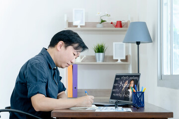 businessman worker sit at desk handwrite watching webinar or training on laptop, make notes busy studying working on computer
