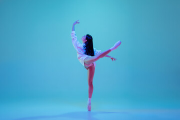 Dreamful. Young and graceful ballet dancer isolated on blue studio background in neon light. Art,...